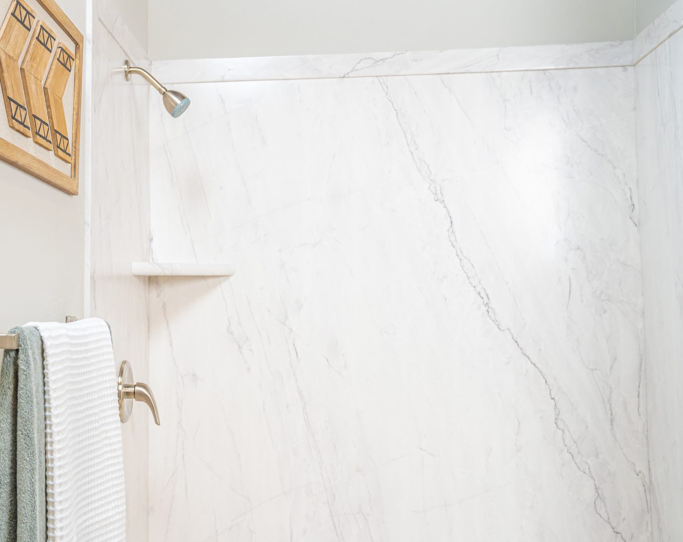 Marble-look walk-in shower with frameless glass